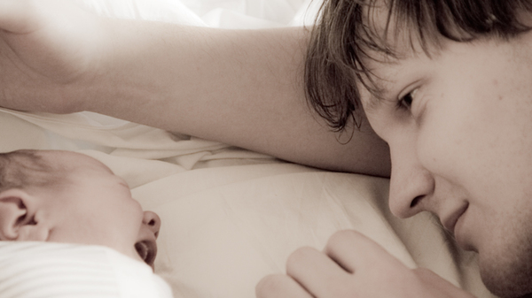 Med thumb father and infant in bed